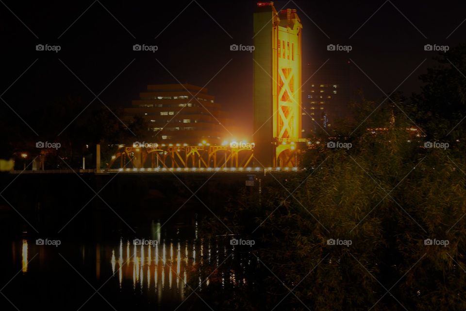 night photography. Golden Bridge. Reflection. Lights. Looking at a golden bridge at nightfall reflecting off the water in Sacramento California.