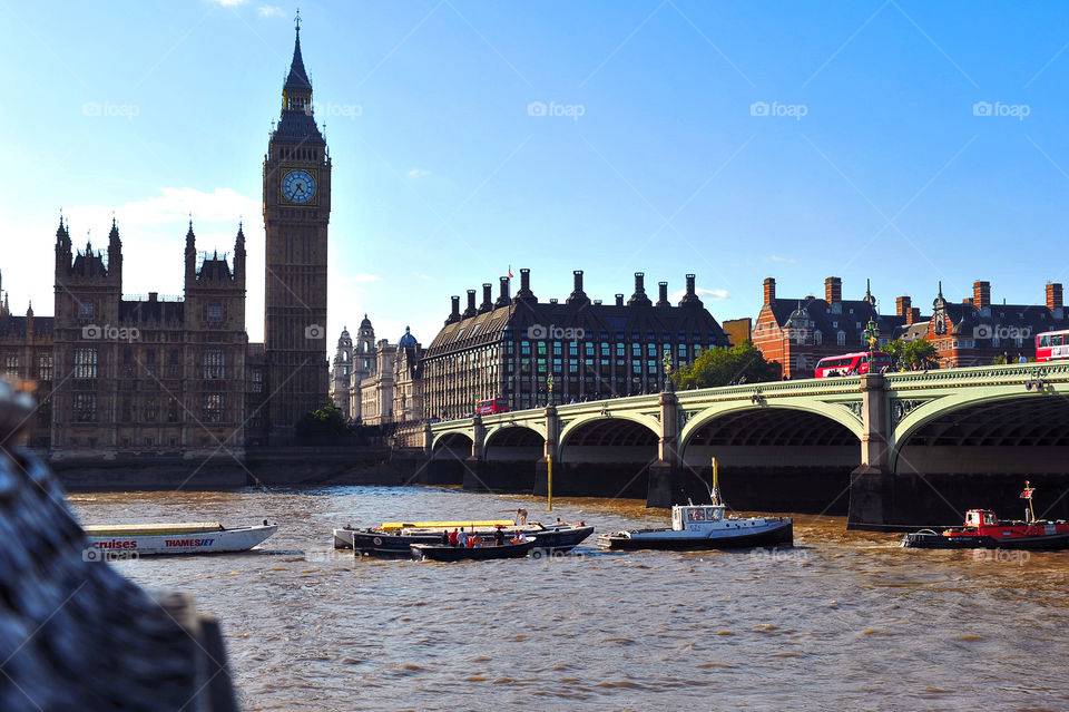 London city with a view of the Thames River and Big Ben. 
