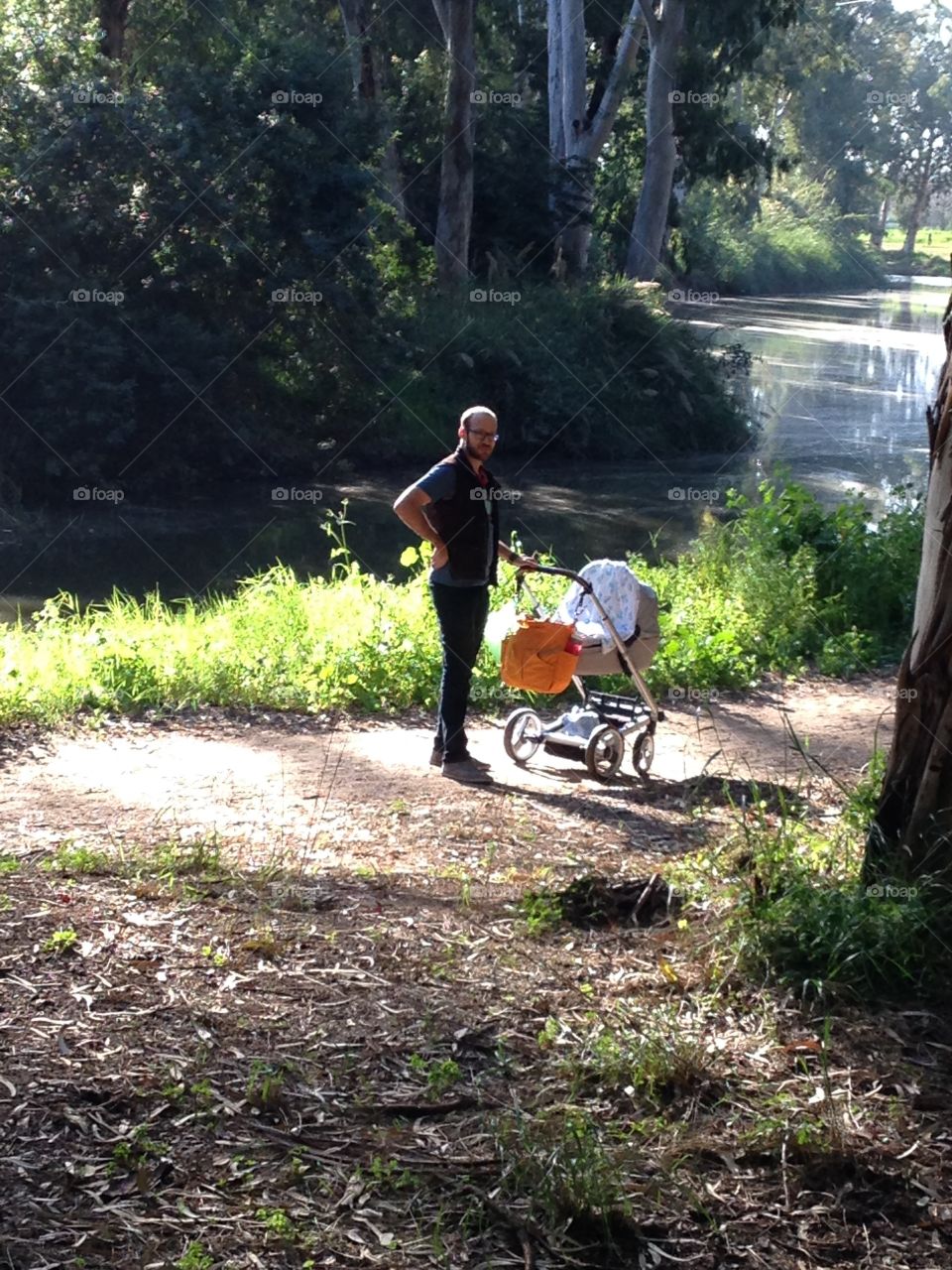 Father going for a walk in the park with his newborn son

