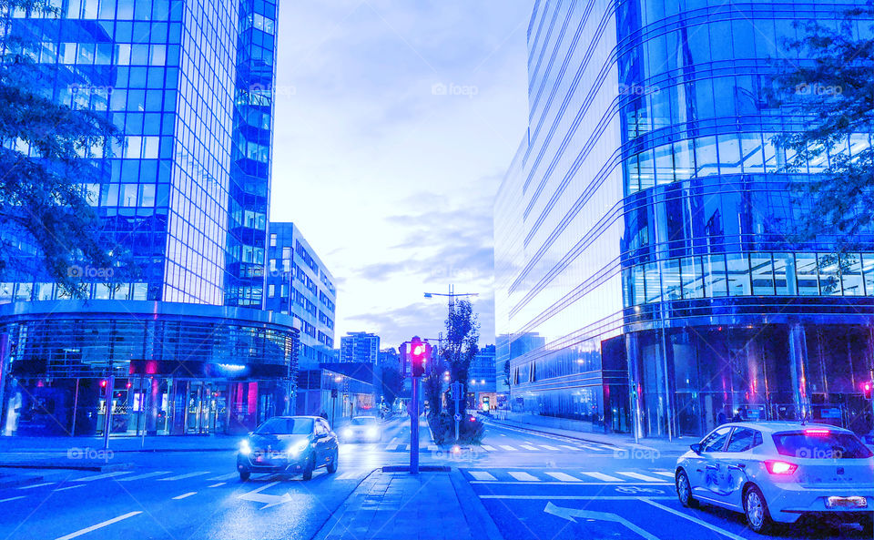 Cold blue morning in the city showing the traffic in the street a'd the morning sky reflected in the glass windows of the business offices