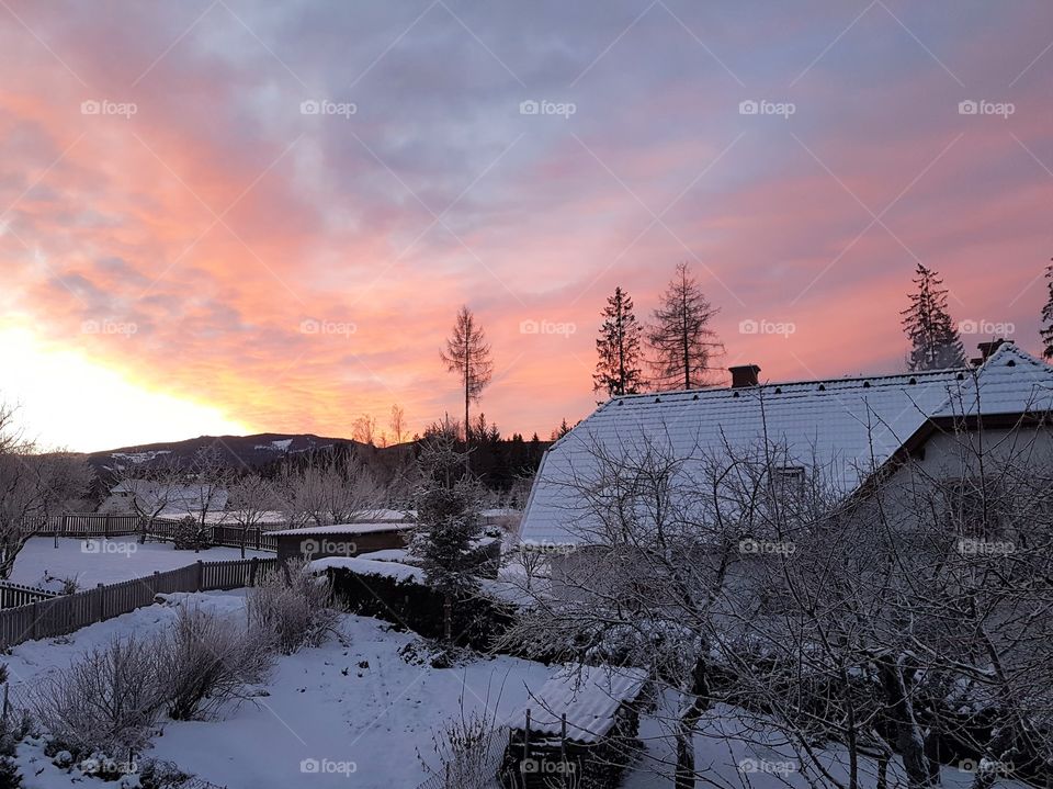 spectacular sunset in the cold and snowy winter in a small village