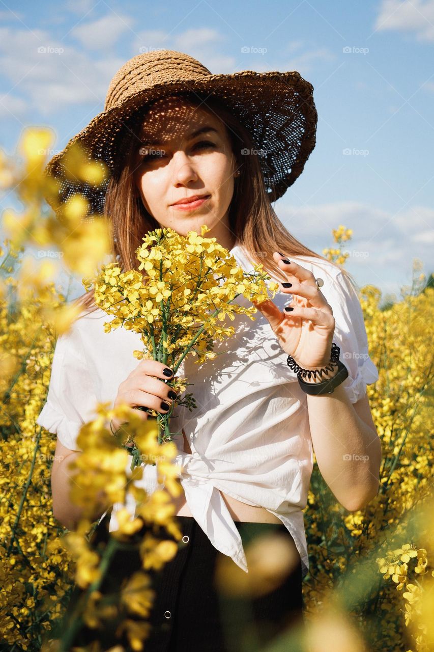 A girl in a beautiful yellow rapeseed field