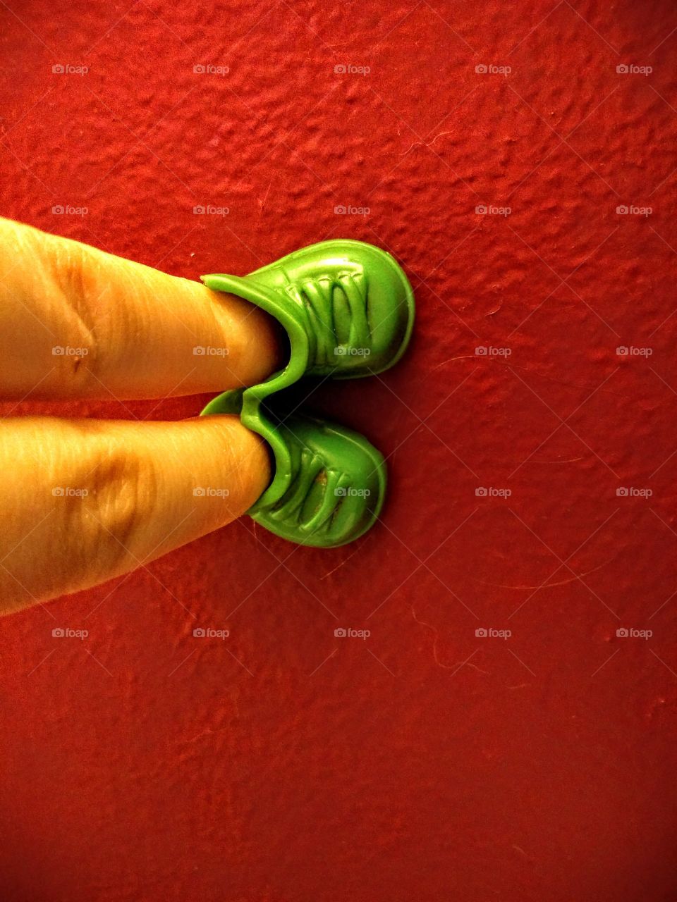 fingers inside of green toy shoes