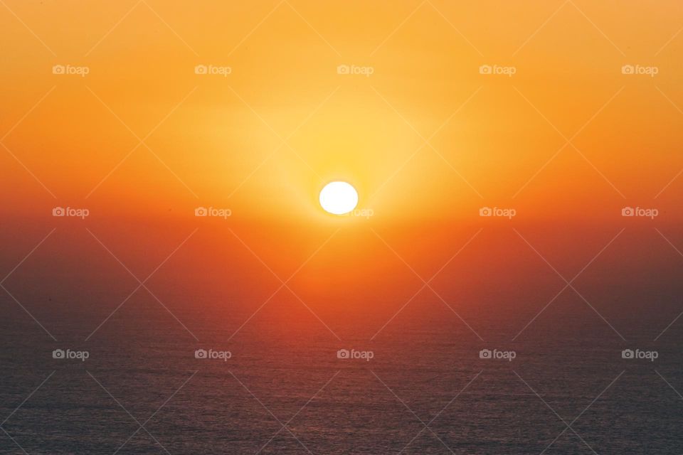 Witnessing an amazing golden sunset above the skyline at the end of the world