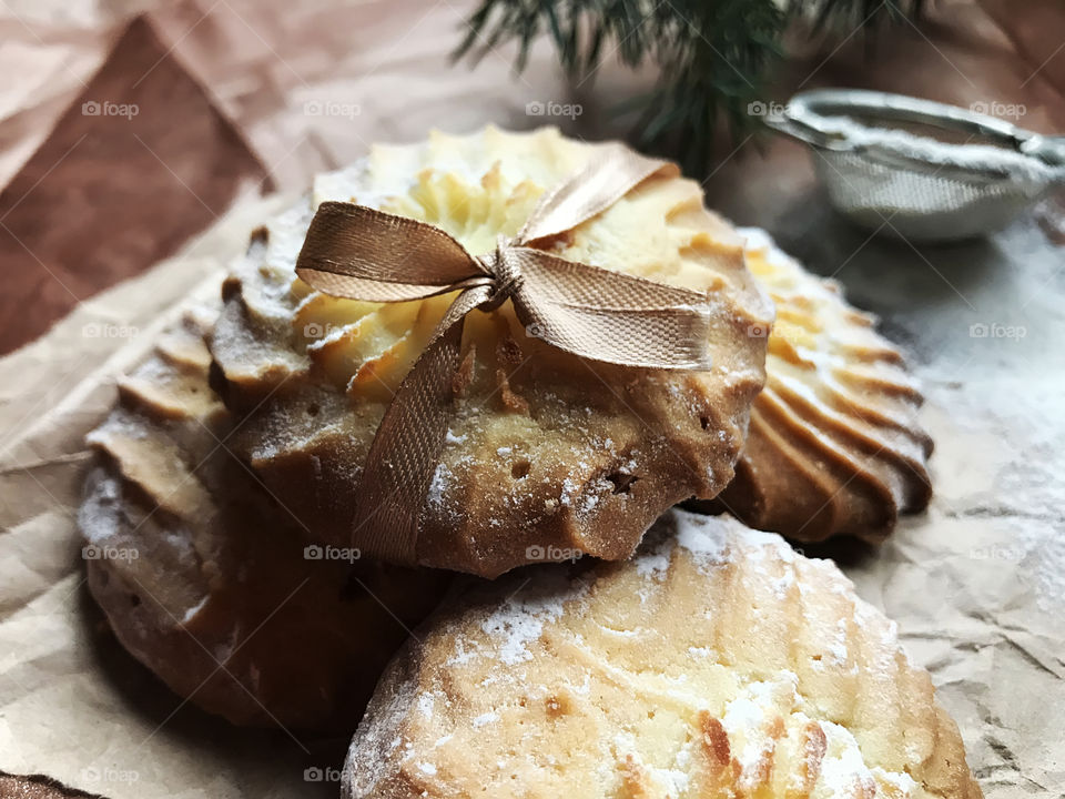 Fresh baked homemade cookies with sugar powder on brown background 