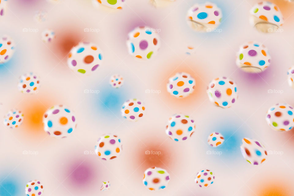 Shapes circles and ellipses using bright colorful circle background and many water drops reflecting the shape. Soft pink and romantic background