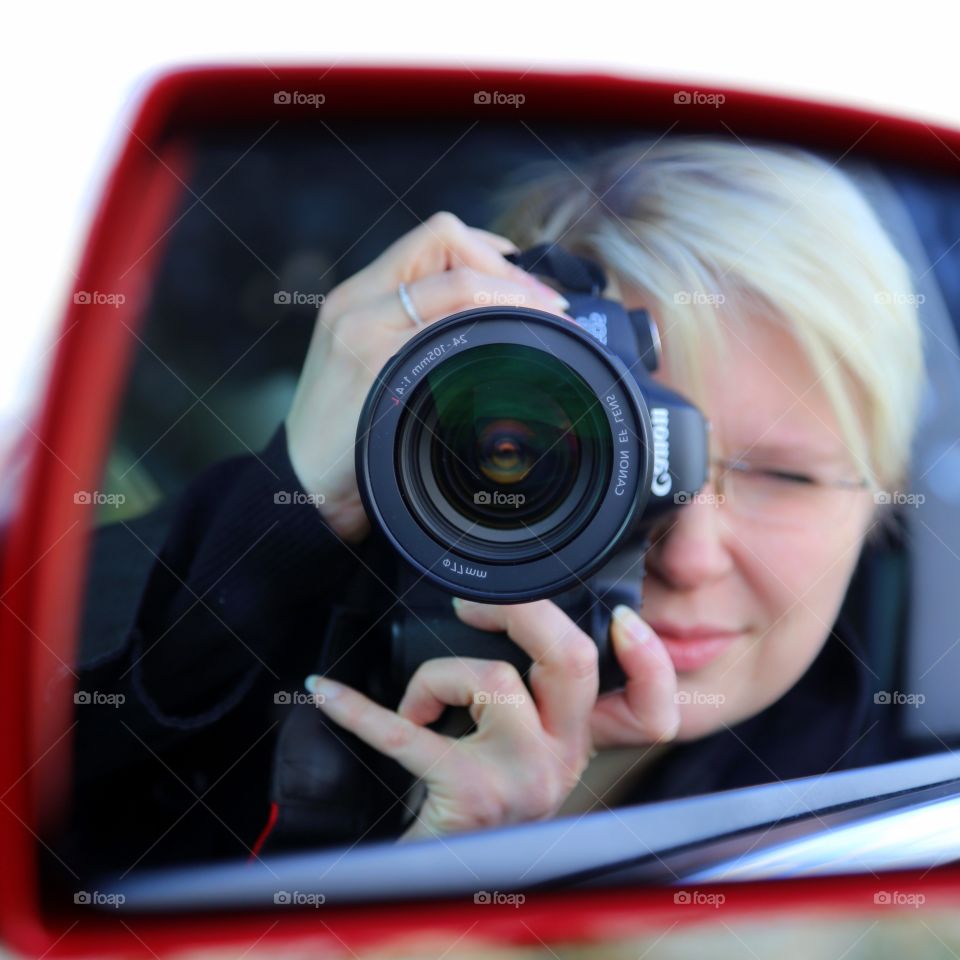 Photographer taking selfie through car mirror: objects in the mirror... 