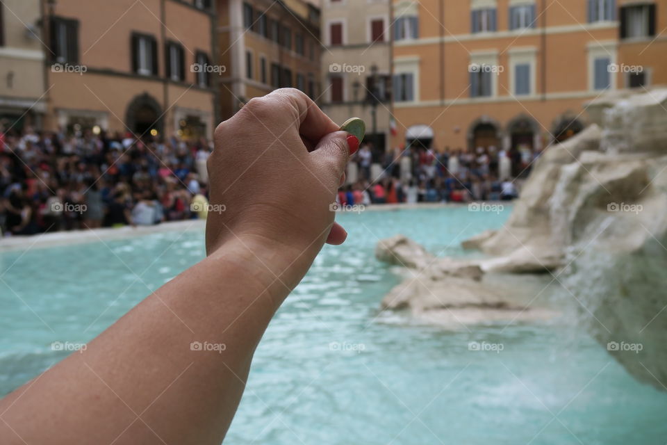 Rome, Italy – summer. Throw a coin at the renovated Fontana di Trevi. The Trevi fountain, after its renovation, gathers daily large crowds. Tradition says that tossing a coin here will make you return to Rome.