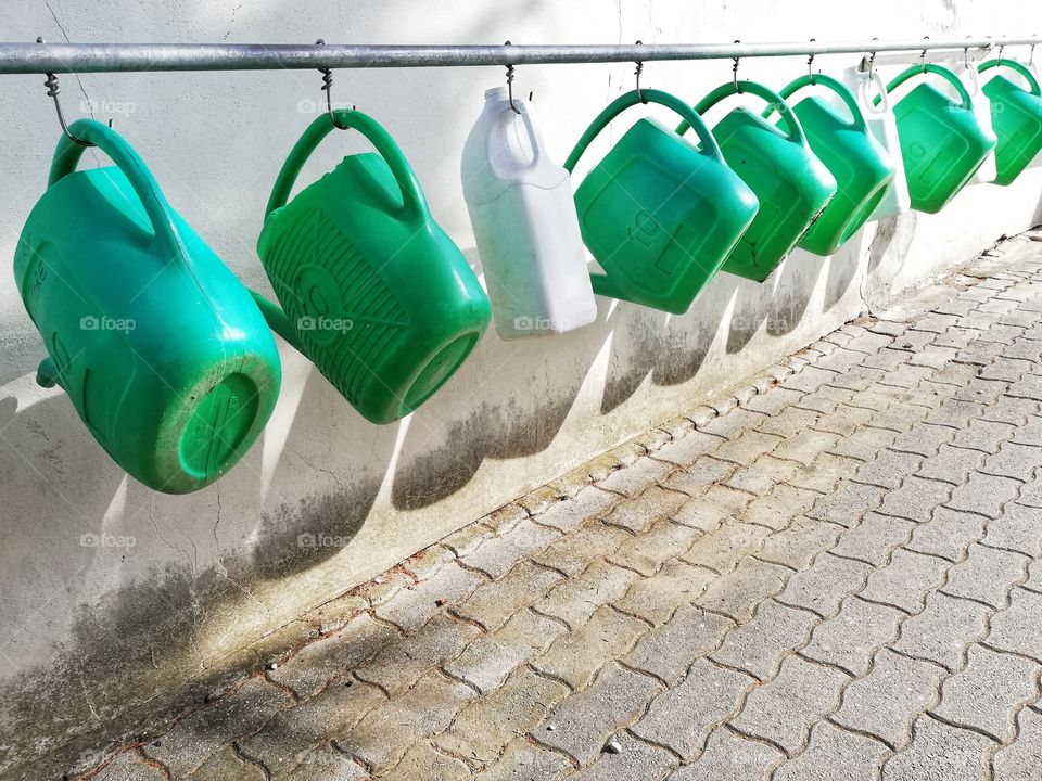 Watering cans hanging in a row