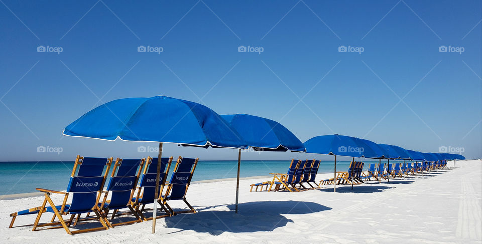 blue beach with chairs.