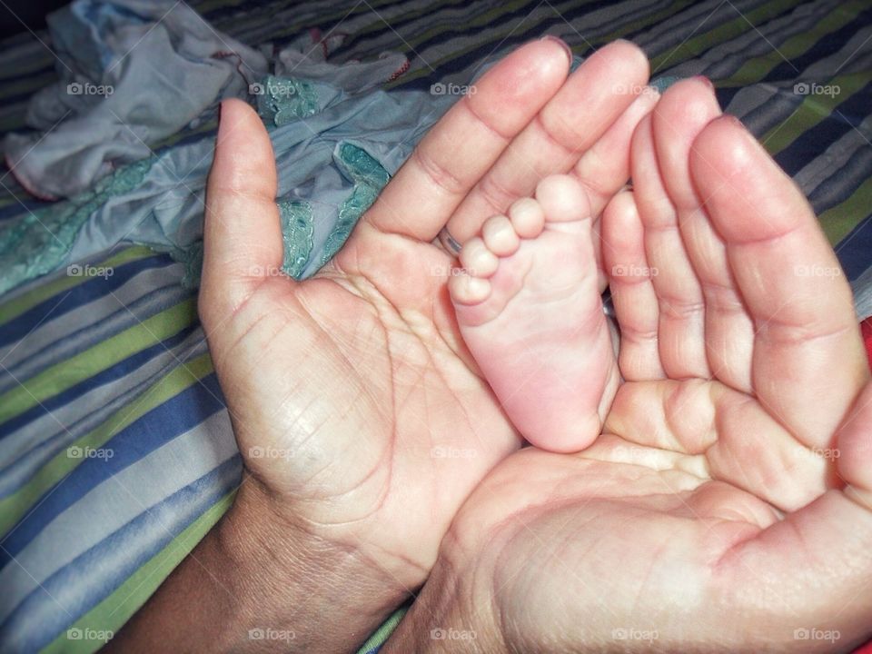 Close-up of a couple's hand with baby's foot