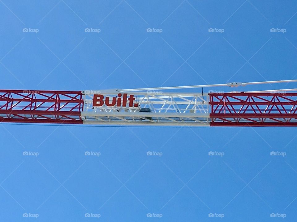 Building crane against a clear blue sky background minimalist 