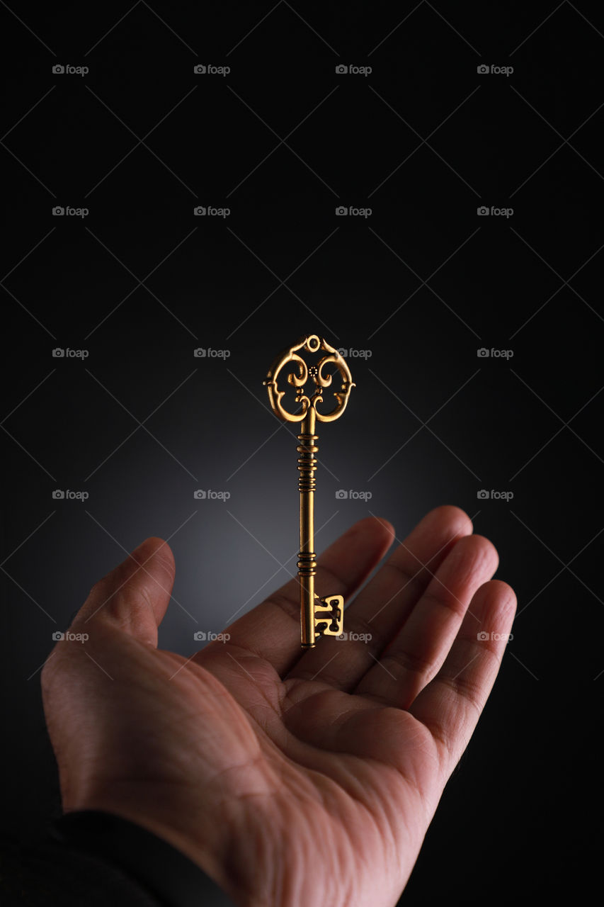 Golden key and hand