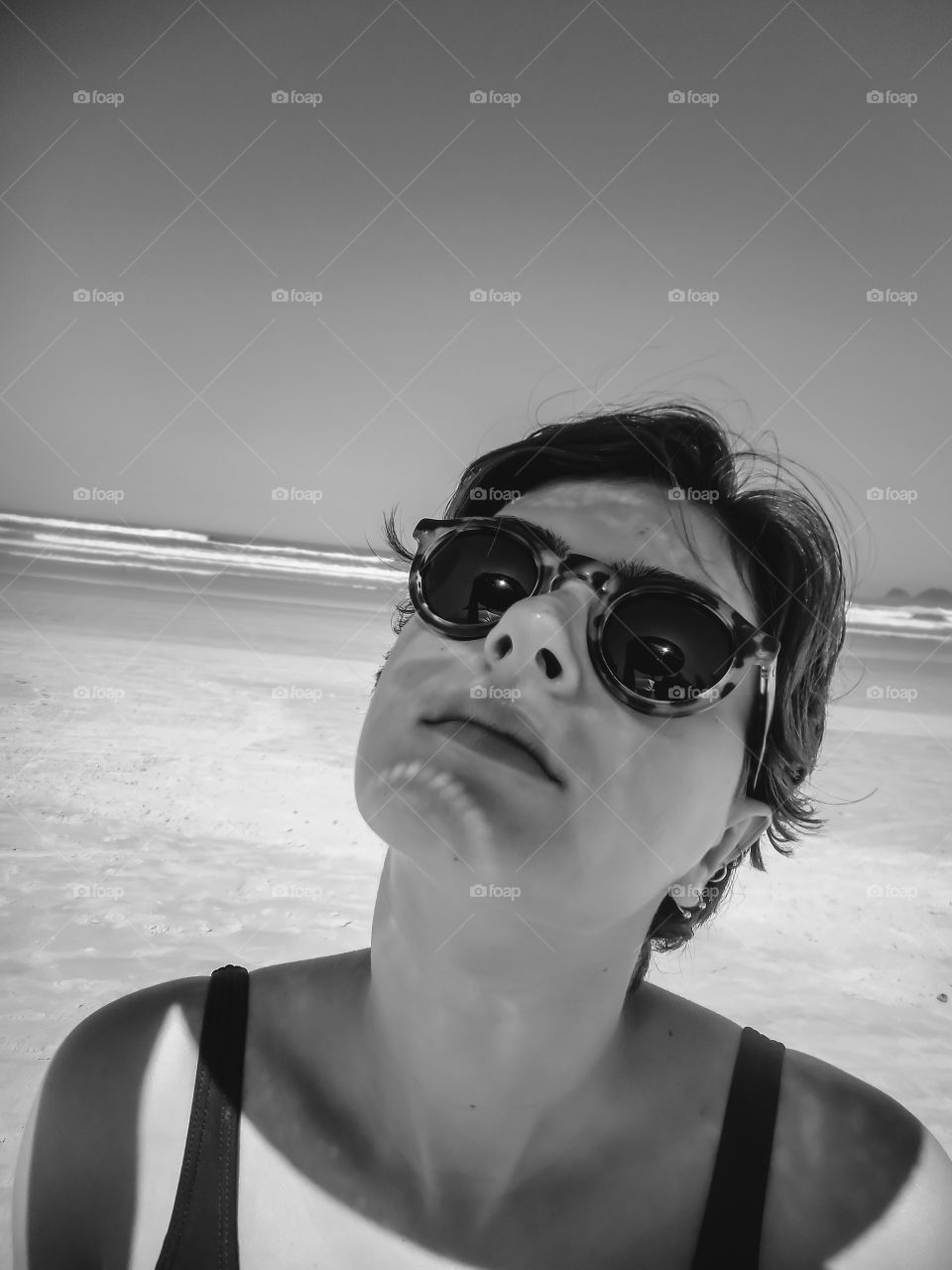 Beautiful Girl at the beach, nice portrait, with shadows on her face. Pretty powerful portrait, black and white photography