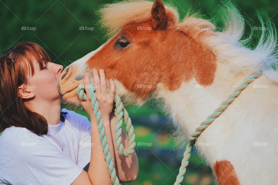 Hey friend. Girl cuddling with a little foal