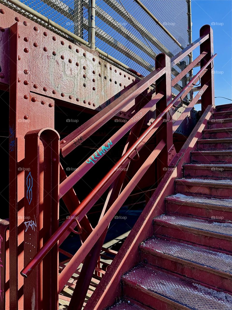 The red metal structures of the “Pulaski Bridge” at “Newtown Creek” have attractive detail such as this railing leading up to the pedestrian lane on the “Greenpoint”, Bklyn side and the bolted together support structure. 2023. Hypnotic Productions