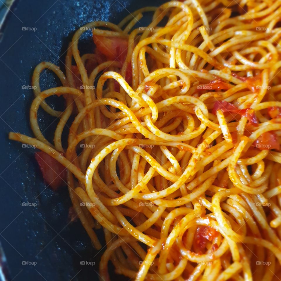 Spaghetti pasta with a tomato sauce in a pan.