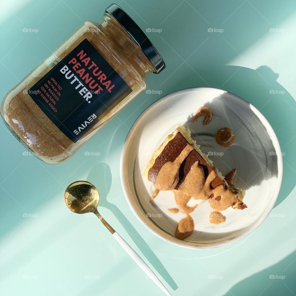 Healthy and nutritious wholesome almond nut butter drizzled on burnt cheesecake, suitable for keto diet