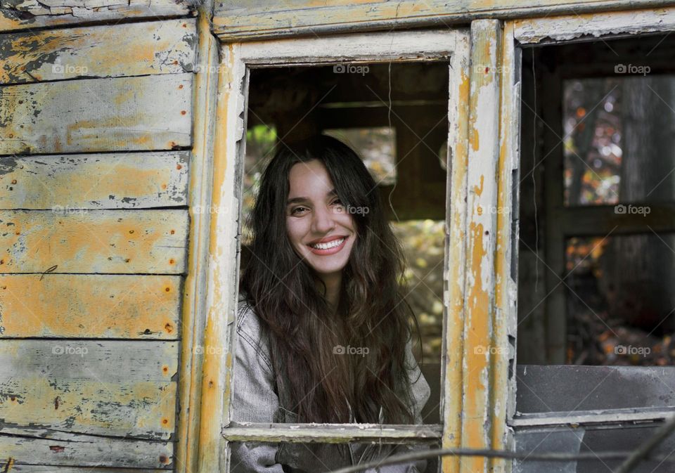 Beautiful woman portrait at the window, smiling
