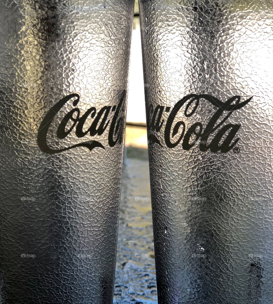 Collectors edition plastic tall Coca-Cola branded drinking glasses closeup 