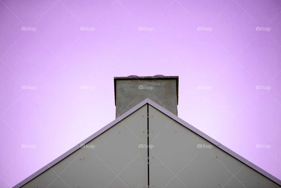 A roof of house on pink sky