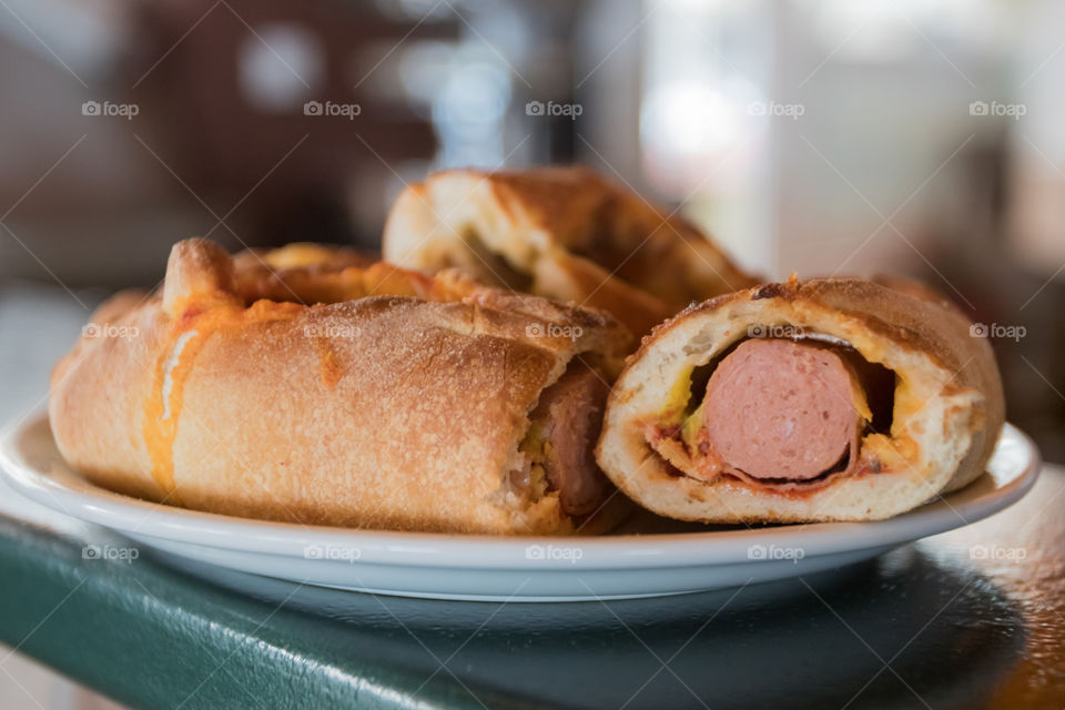 bread stuffed with frankfurter sausage ketchup and mustard on a plate