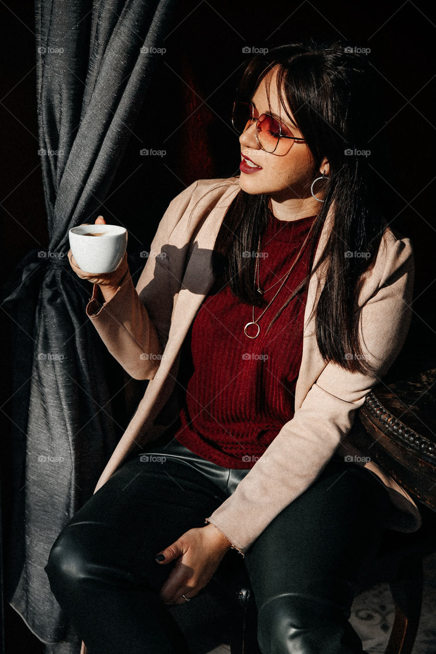 Beautiful brunette girl smile and take cup of coffee in street cafe