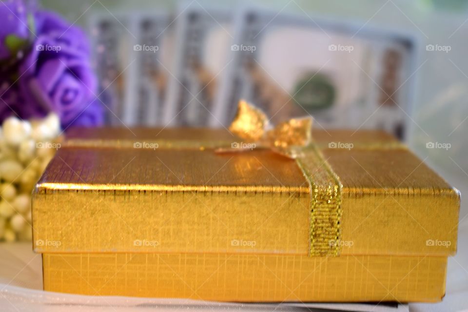 Golden gift box with flowers and money