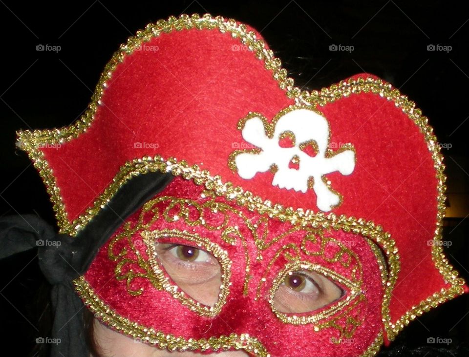 close up of a young woman's face wearing a red costume pirate mask and hat for a Halloween party