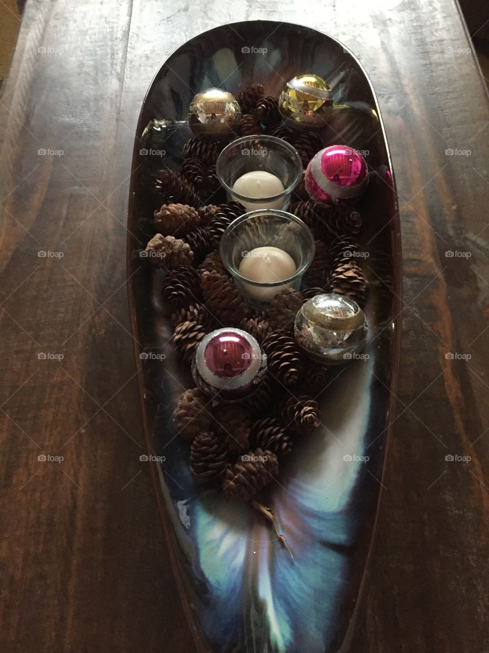 Decorating for the holiday season can be made simple and inexpensive a decorative dish bring in a little bit a nature add a couple do you lights and some glittery balls makes a beautiful centrepiece