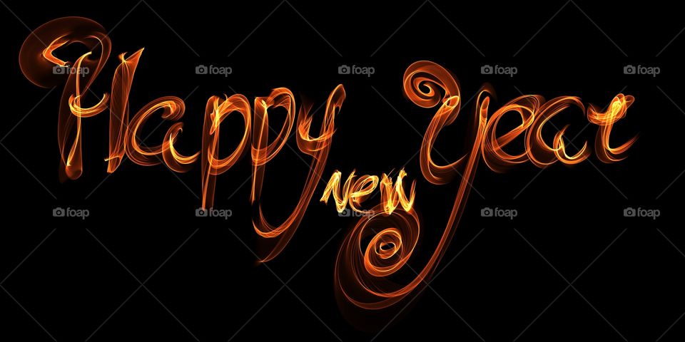 Happy new year isolated words lettering written with fire flame or smoke on black background
