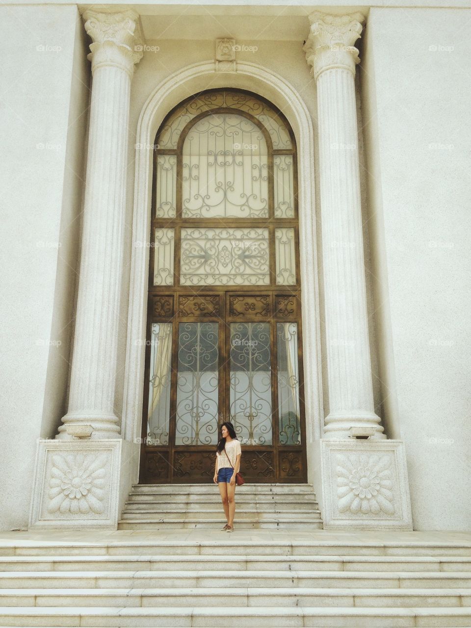 A girl standing in front of the Koh Pich Hall door