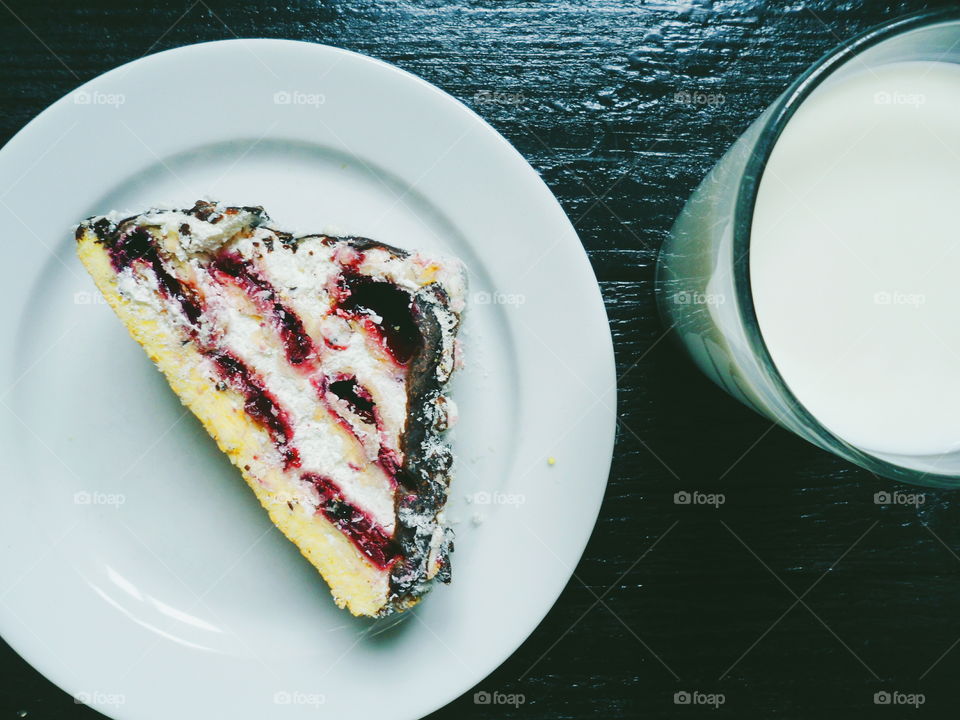 a cake with cherries and chocolate, and a cup of milk