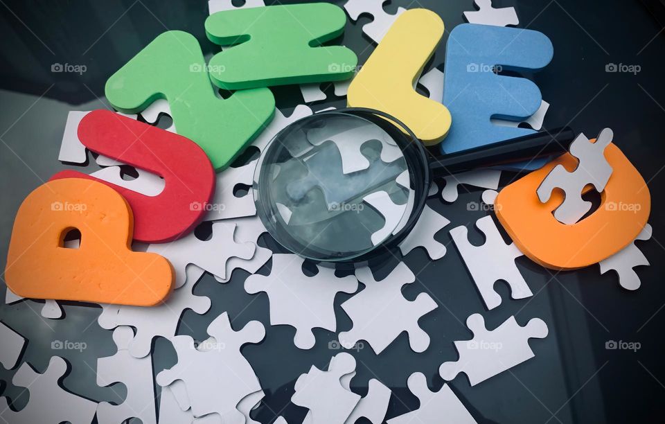 PUZZLED Word With Kids Letterings And Magnifier To Enlarge Puzzle Pieces In The Center