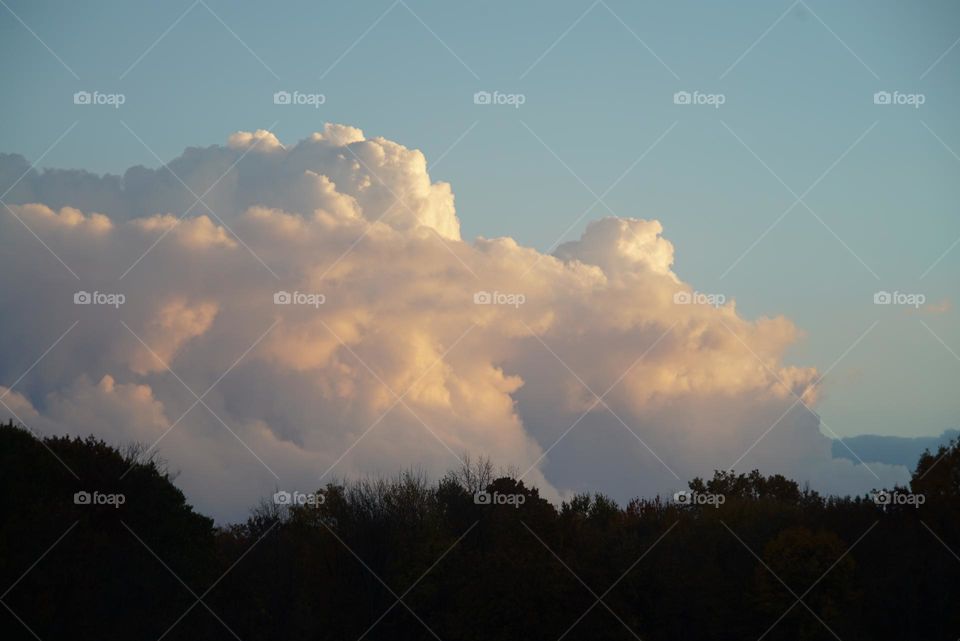 Fluffy thick clouds as the sun goes down over Michigan farmland in the fall