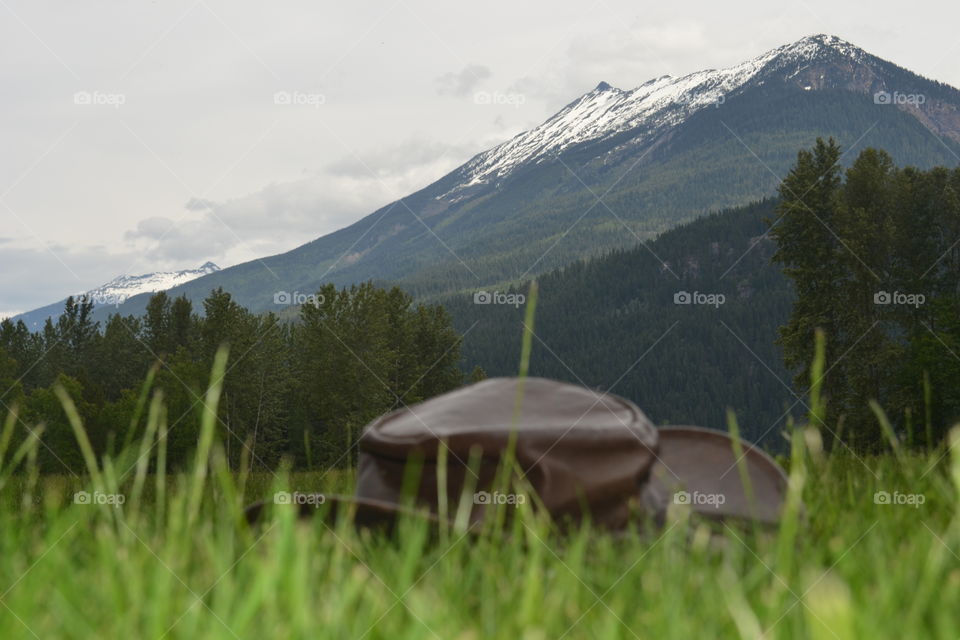 Australian bush hat resting on grass in meadow in Canada's Rocky Mountains in Banff national park 