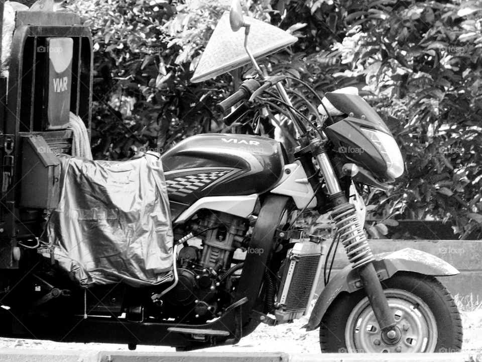Raincoats, hats made of caping bamboo on motorbike viar