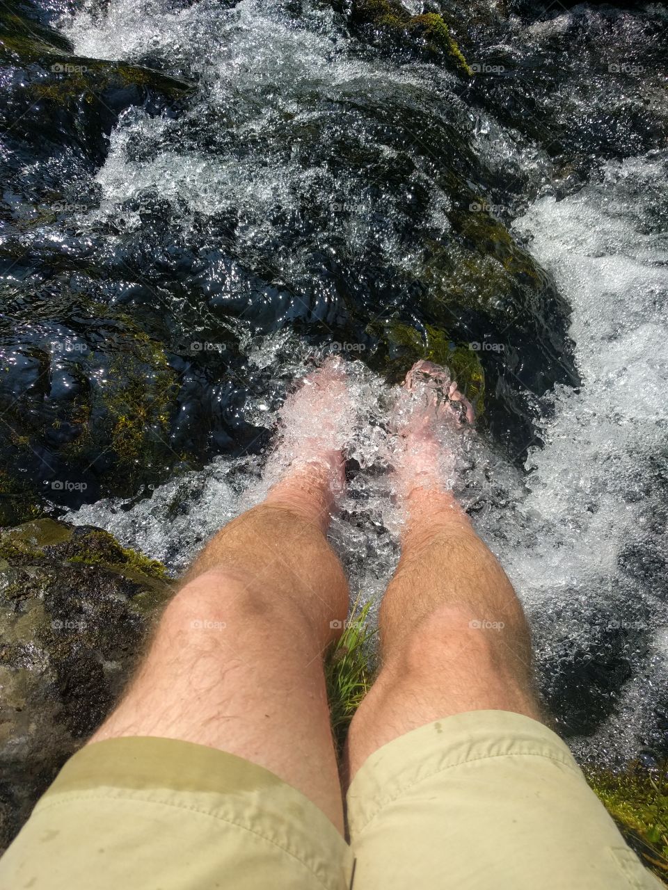 chilling feet in glacial high mountain stream after hiking