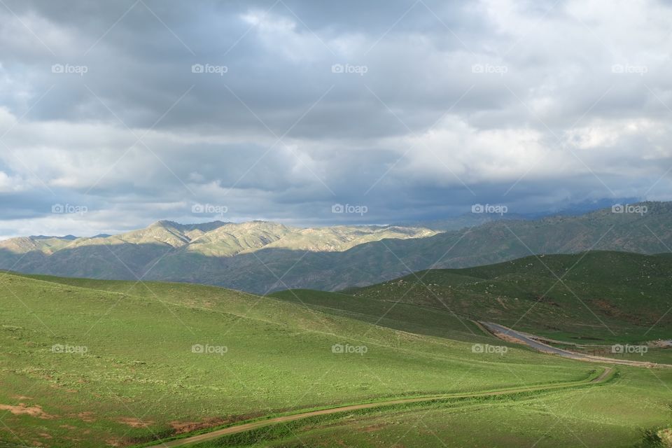 Clouds gather over green hills