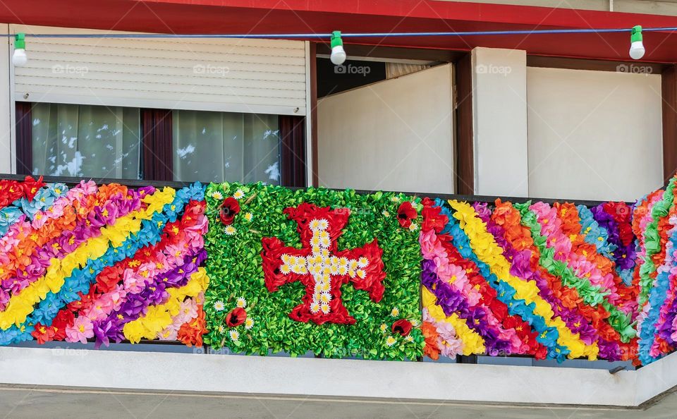Balcony decorated with colourful paper flowers for Festas Dos Tabuleiros in Portugal