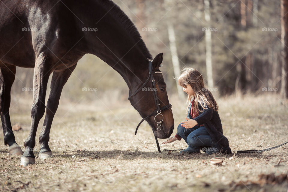 Little girl with horse, outdoor portrait 