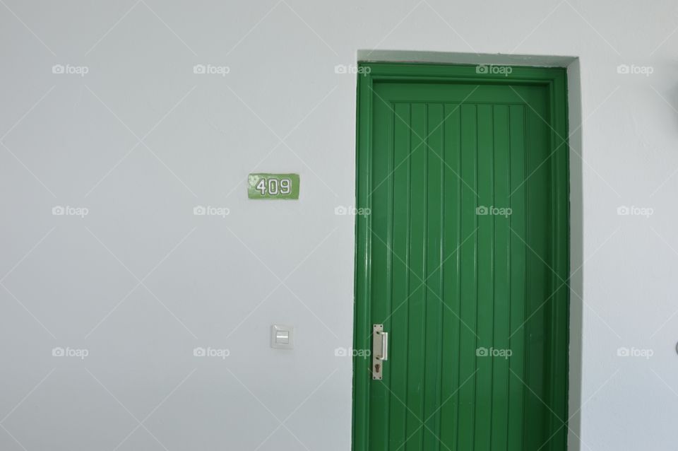 Photo of a green door and a white building or house