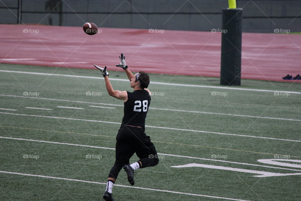 Make the catch. Football player catching a football