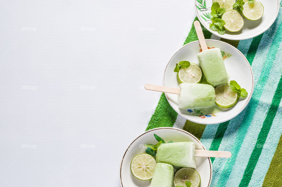 Green minty popsicles arranged in white ceramic plates.