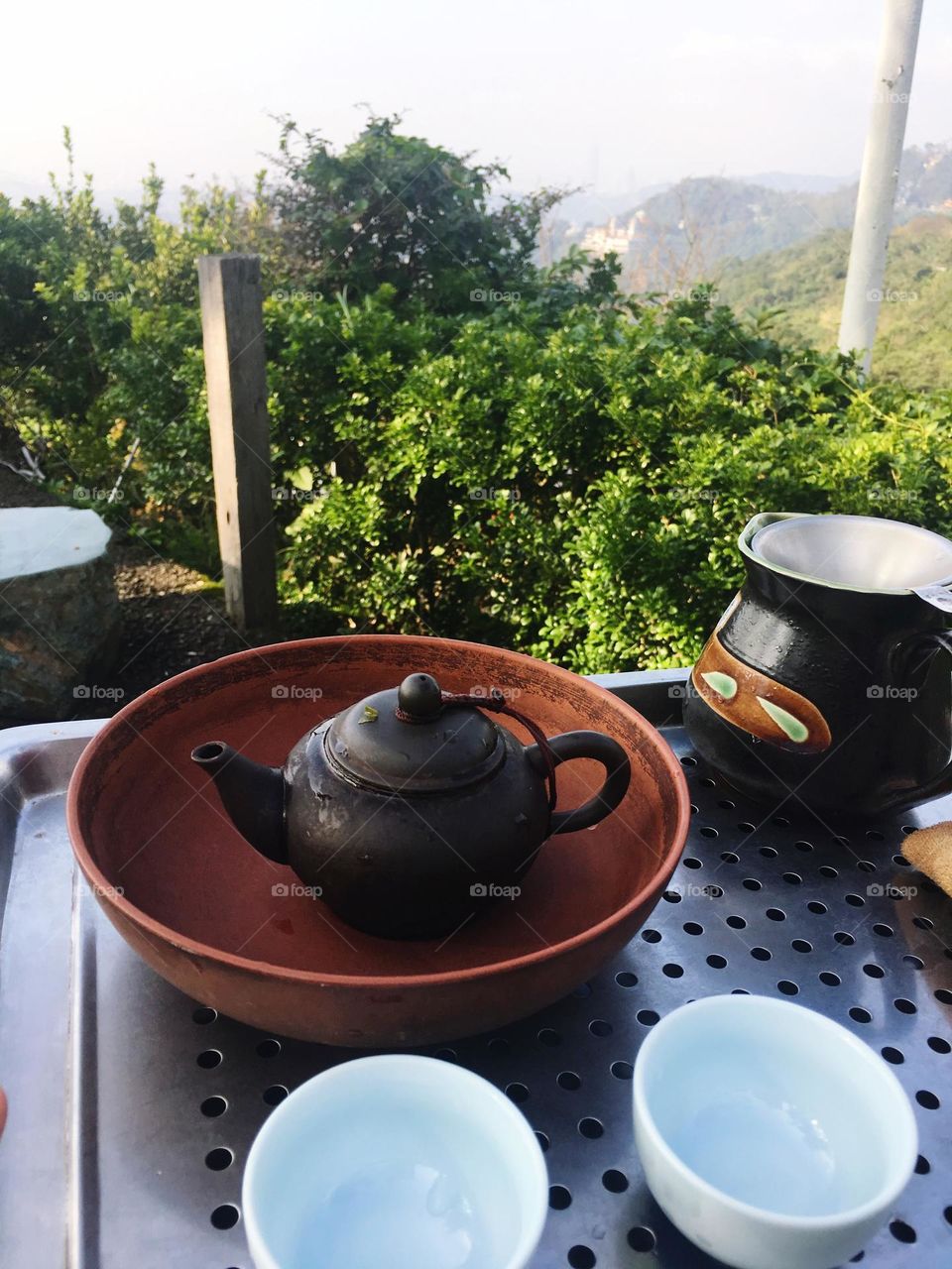 Tea cups and tea pot by the mountain