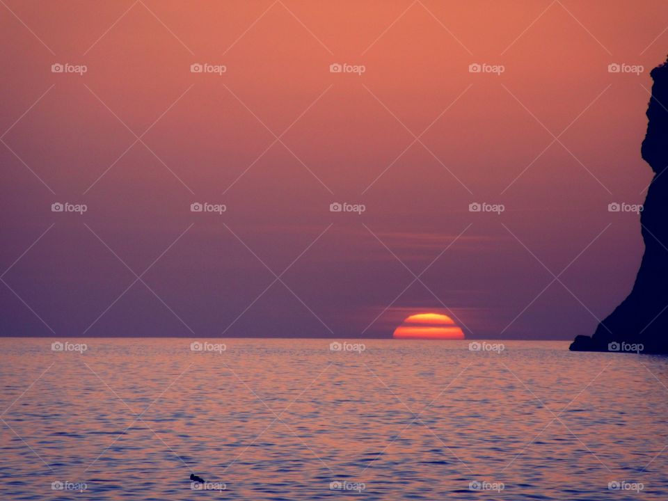 Scenic view of calm beach at sunset