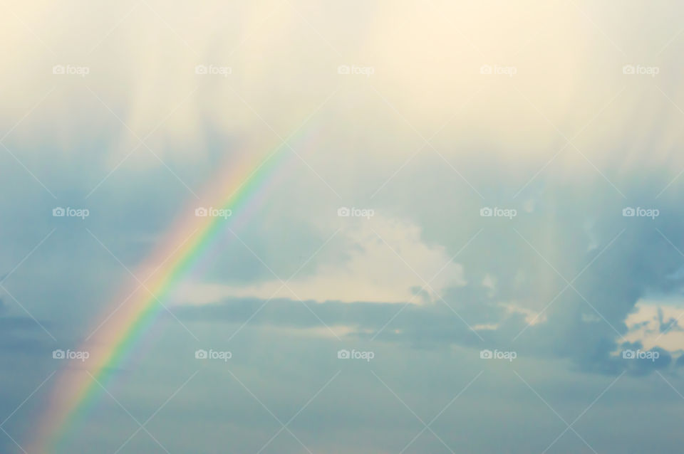 Rainbow in the heavens cloudy sky with beautiful dreamlike summertime cloudscape and beauty in nature nephology and physics landscape photography background 