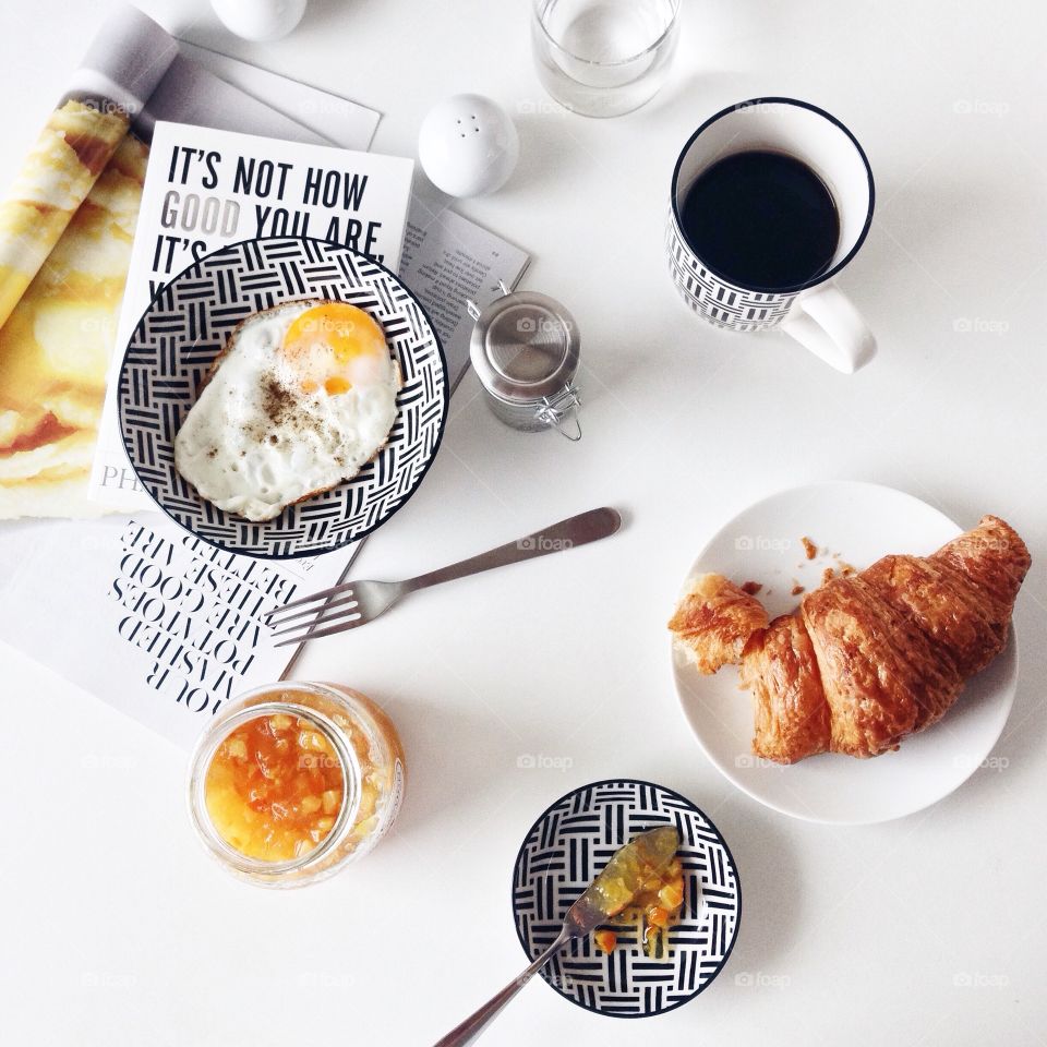 Daily breakfast. Classic breakfast with fried egg, wholewheat croissant and black coffee.