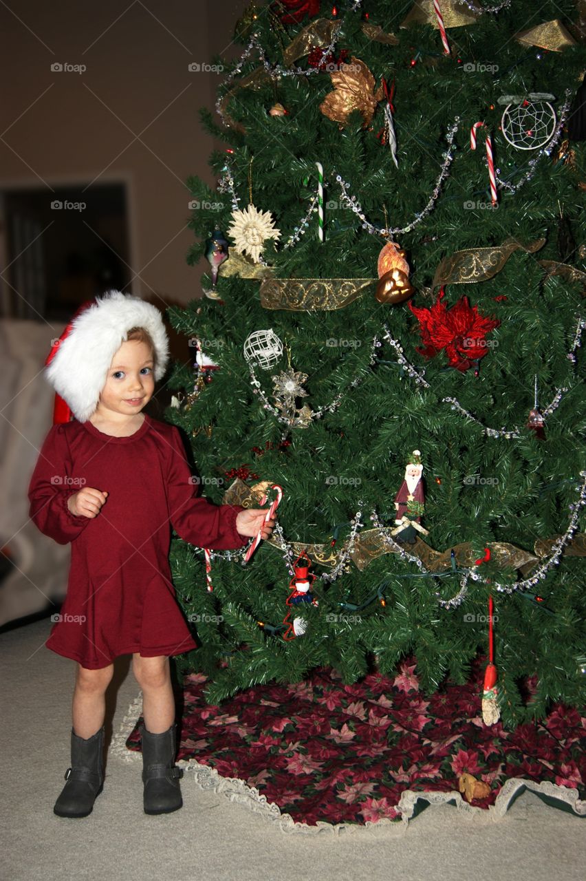 Girl standing in front of christmas tree
