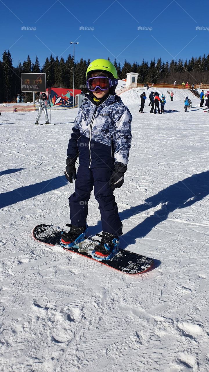 Little snowboarder in winter